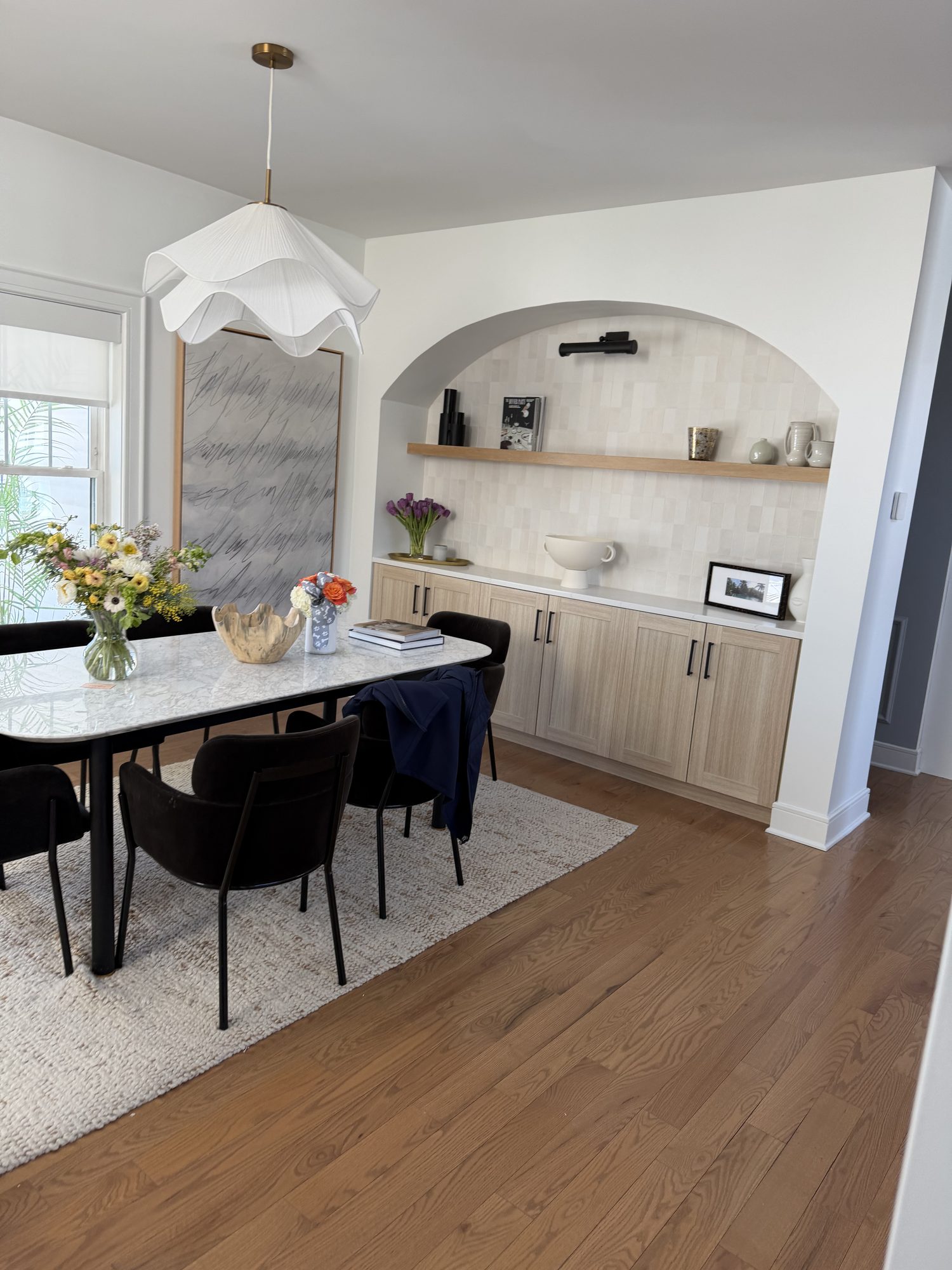 Dining room with arched built-in, pendant light, and marble table